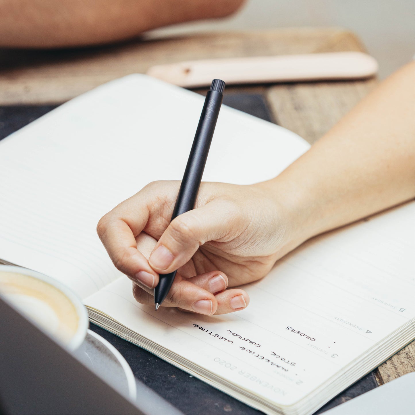 hand writing using a black aluminium rollerball pen