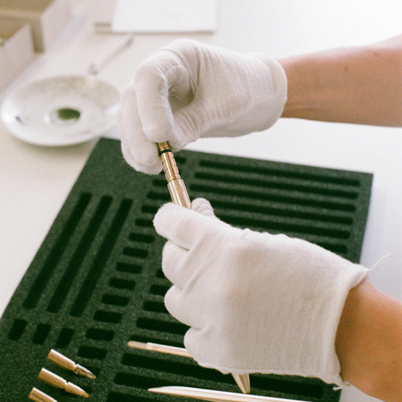 Hands assembling an ajoto brass pen